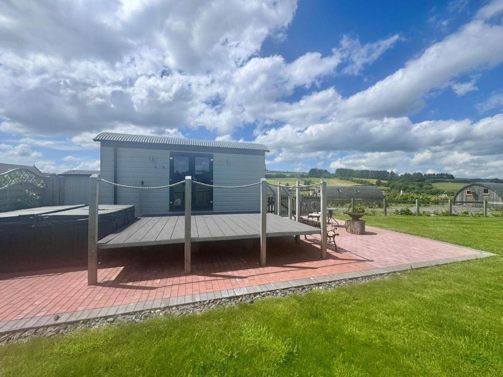 a small white building with a bench in a field at 1 Bed in Rhayader oc-90278 in Saint Harmon