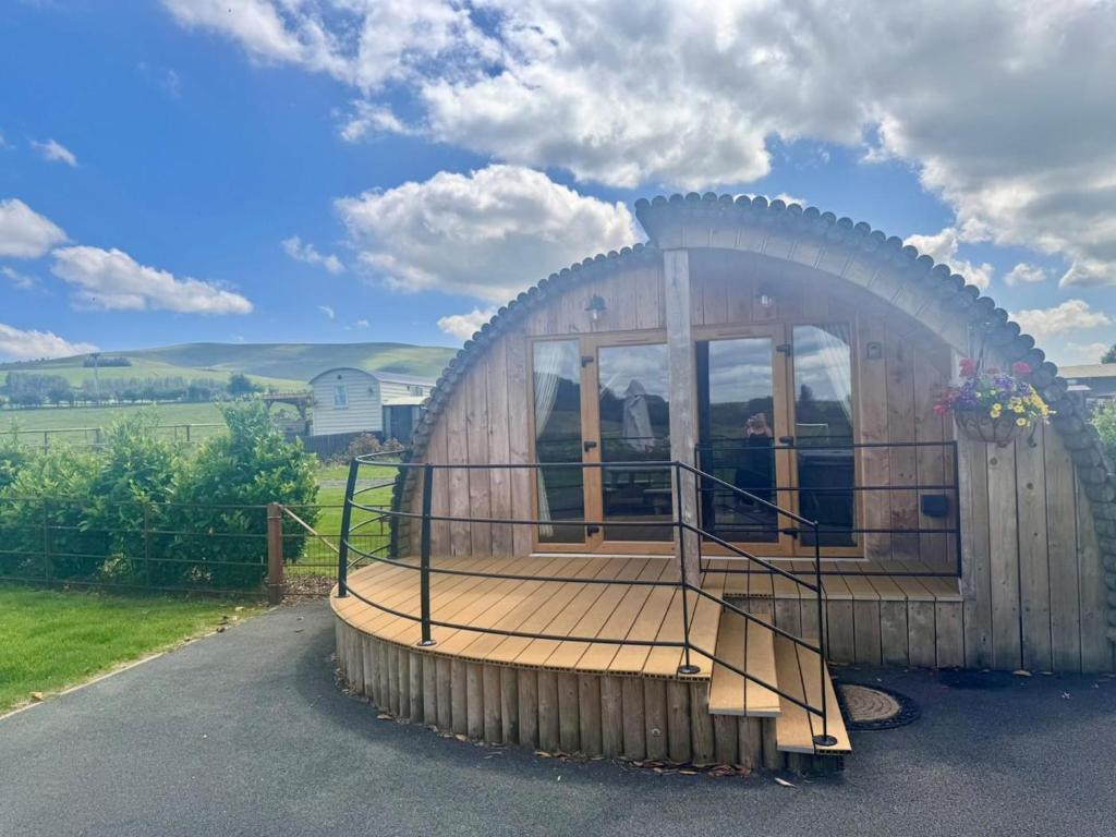 a circular wooden house with a porch and windows at 2 Bed in Rhayader oc-90276 in Saint Harmon