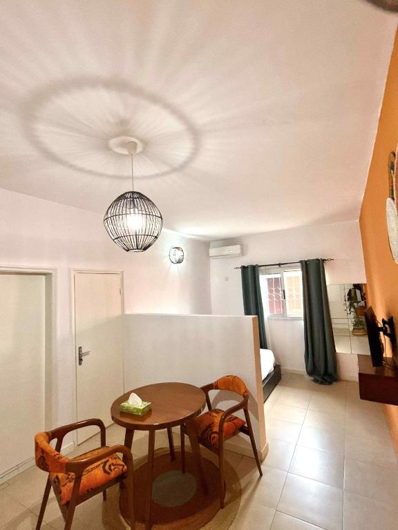 a dining room with a table and chairs in a room at Residence Mamie Léo in Abidjan