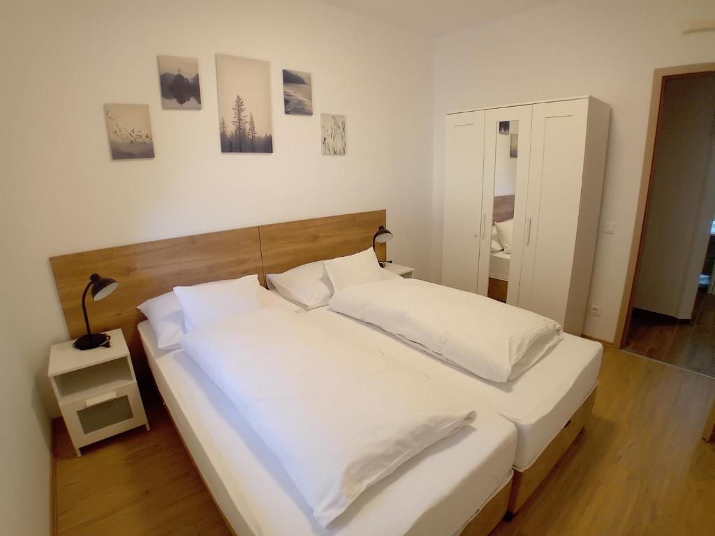a bedroom with a large bed with white sheets and pillows at Berki Apartman in Körmend