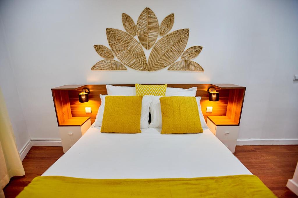 a bedroom with a large white bed with yellow pillows at Tranokely II in Antananarivo
