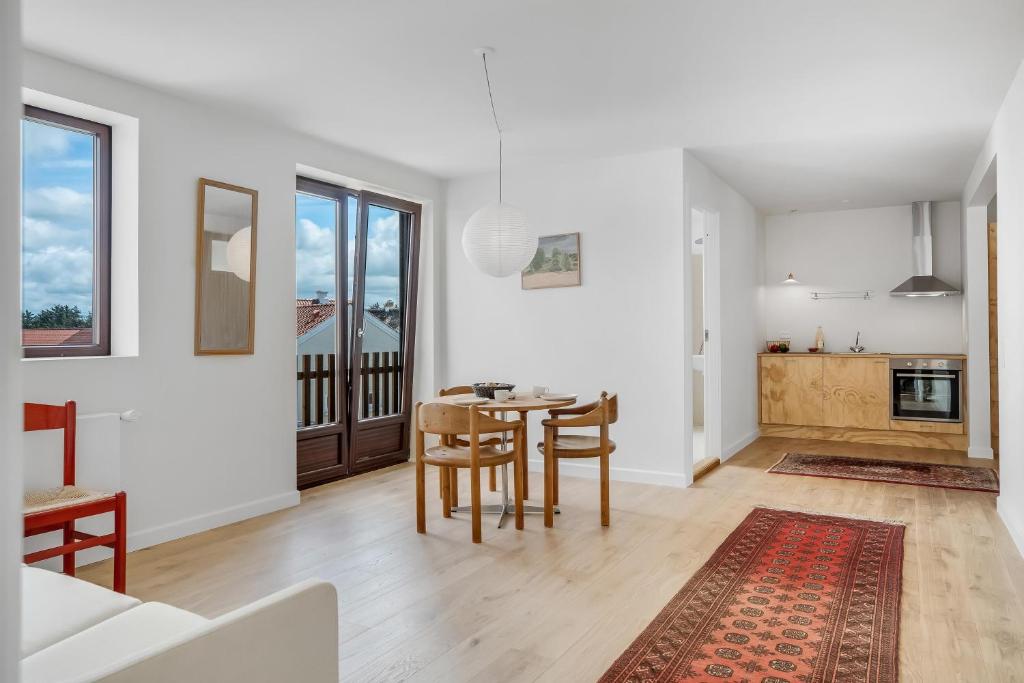 a kitchen and dining room with a table and chairs at God Plads Og God Beliggenhed I Løkkenshus in Løkken