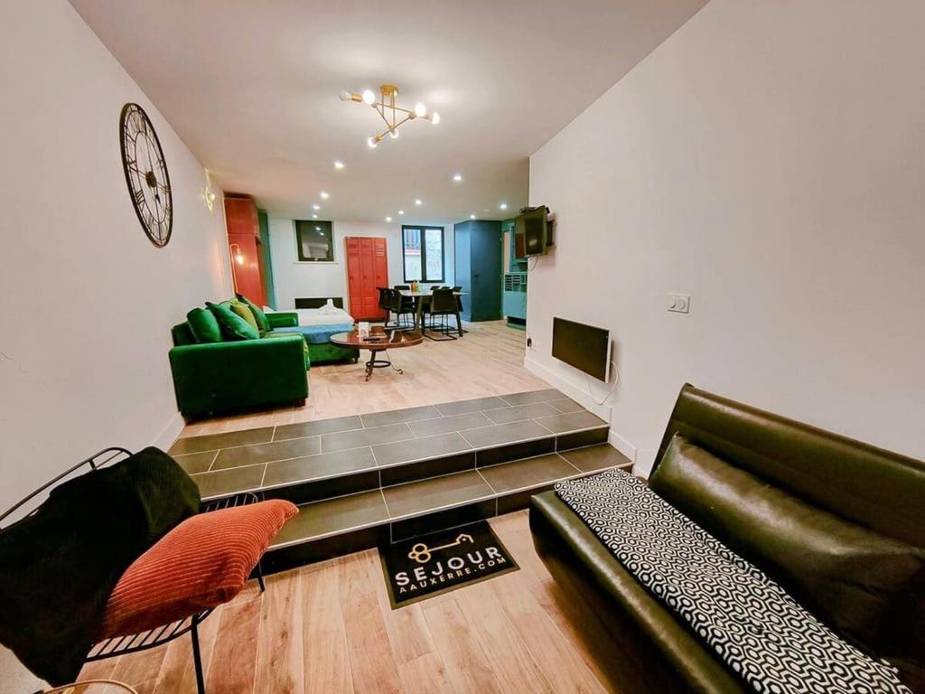 a living room with a couch and a tv at Milliaux - Bail Partner in Auxerre