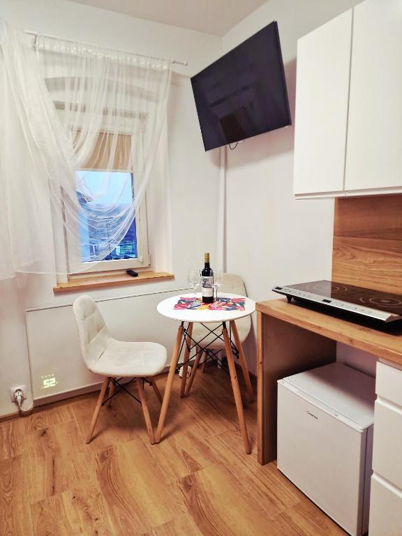 a small kitchen with a table and a white chair at Dzień dobry w Szczytnej in Szczytna