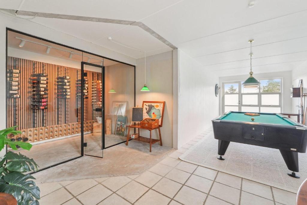 a room with a pool table and a wine cellar at Holstvej 21 Holiday Home For 12 Guests With An Extra Bonus in Blokhus