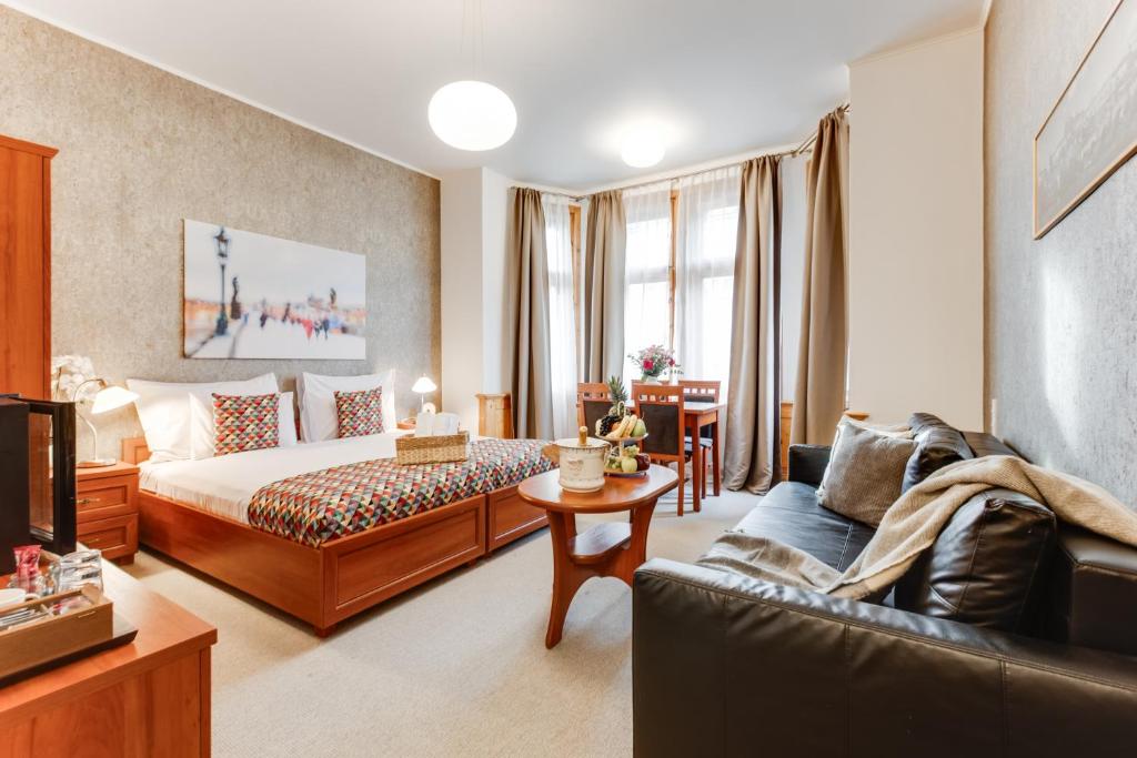 a hotel room with a bed and a couch at Kafka Prague rooms in Prague