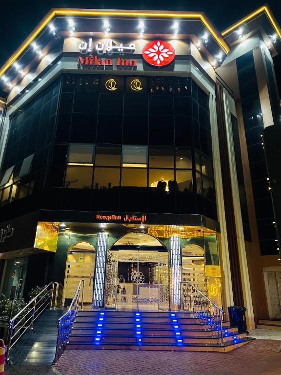 a building with blue stairs in front of it at ميلان إن للشقق المخدومه in As Sayl aş Şaghīr
