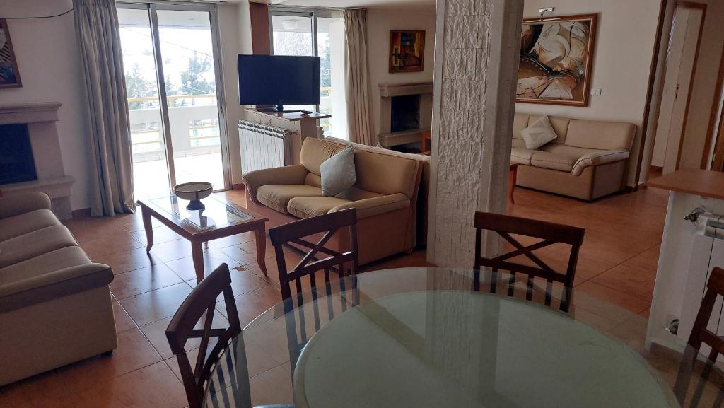 a living room with a glass table and chairs at Spacious 4-Bedroom Chalet - Ski and Summer in Kfardebian