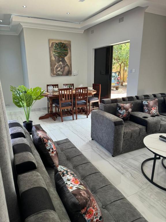 a living room with couches and a dining room at Elephant's Crest Lodge in Victoria Falls