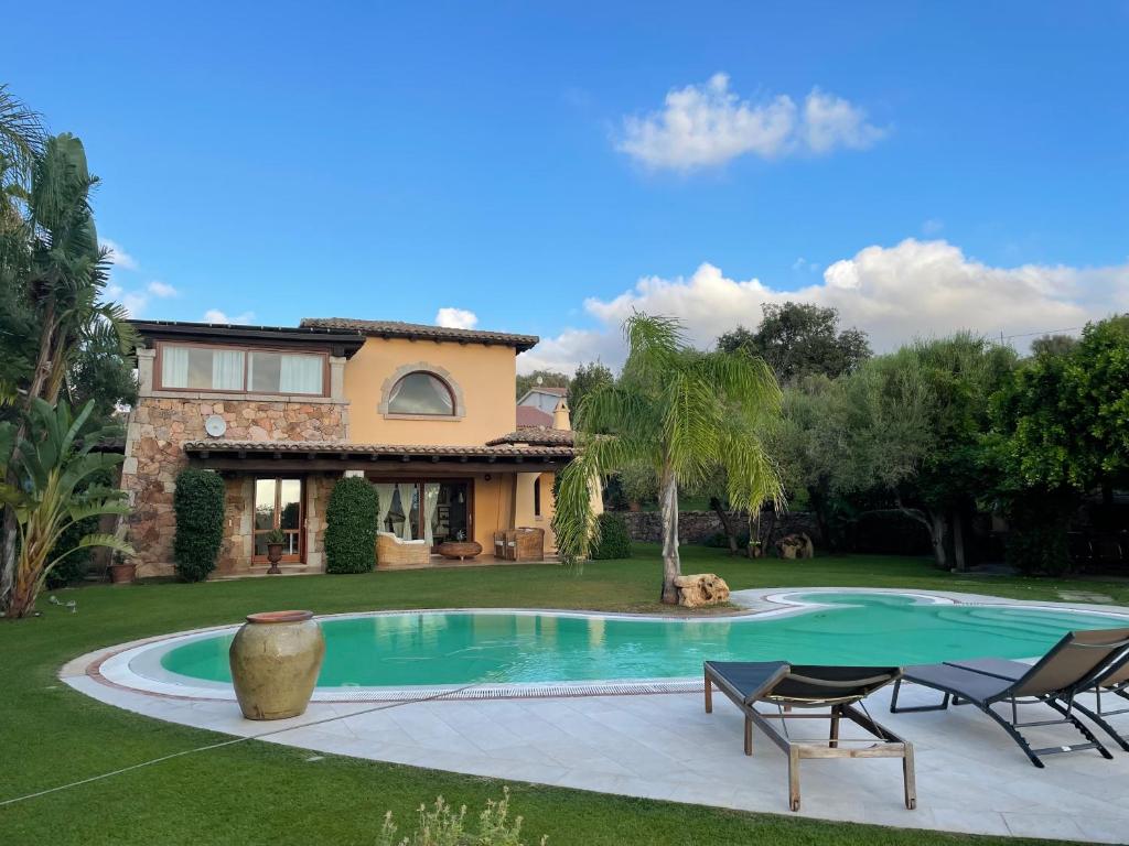 a villa with a swimming pool in front of a house at Villa Babsy con piscina privata in San Teodoro