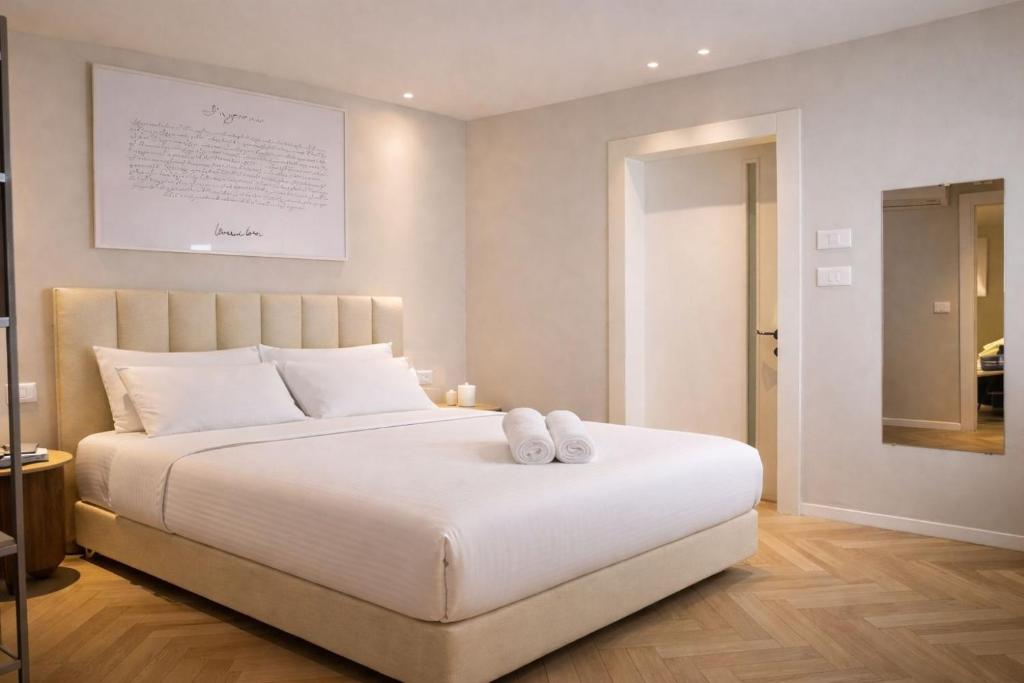 a bedroom with a white bed with two white shoes on it at Merian Eilat in Eilat