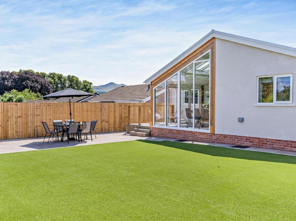 a patio with a table and chairs on a lawn at 3 Bed in Brecon oc-92341 in Brecon
