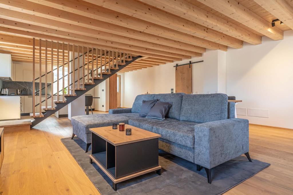 a living room with a blue couch and a table at Duplex Cermis in Cavalese
