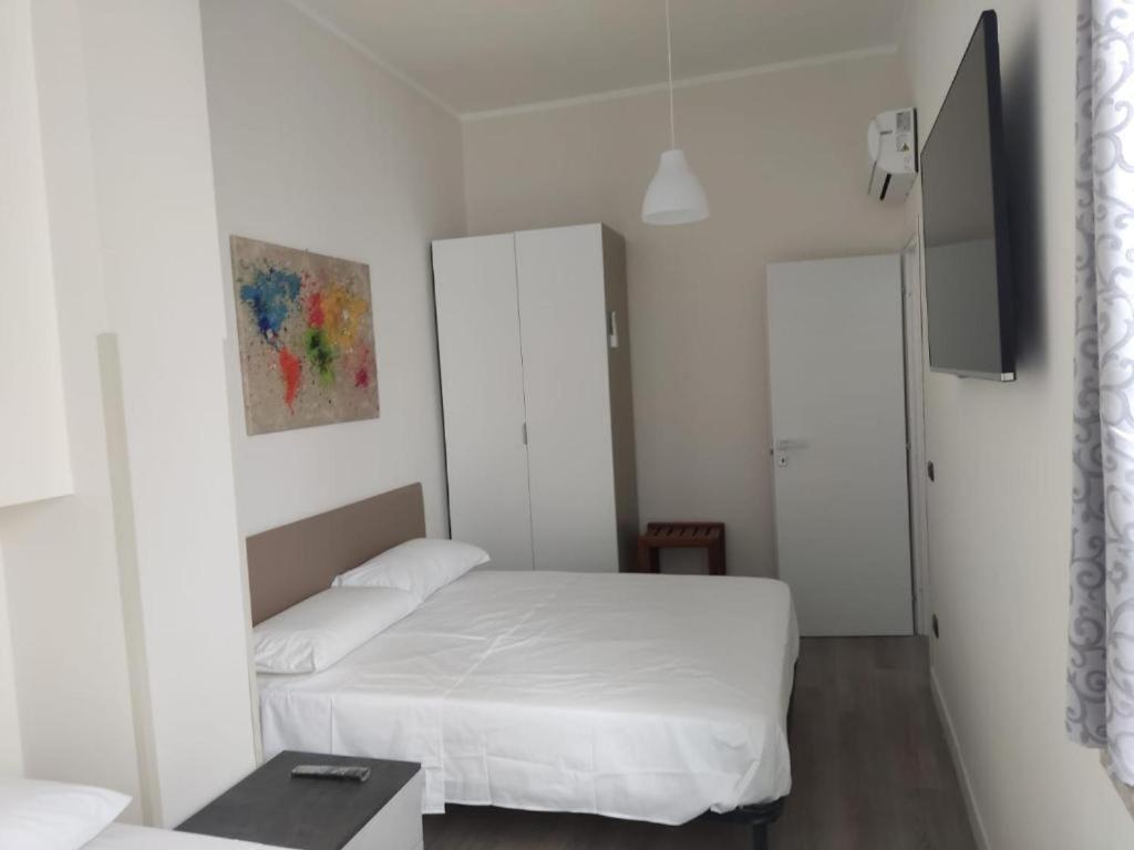 a white bedroom with a bed and a table at Siderno A1passo in Siderno Marina