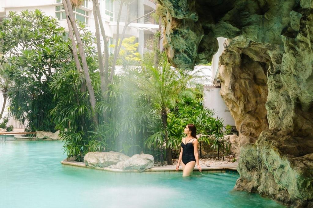 a woman standing in the water at the water park at Dusit Suites Hotel Ratchadamri, Bangkok in Bangkok