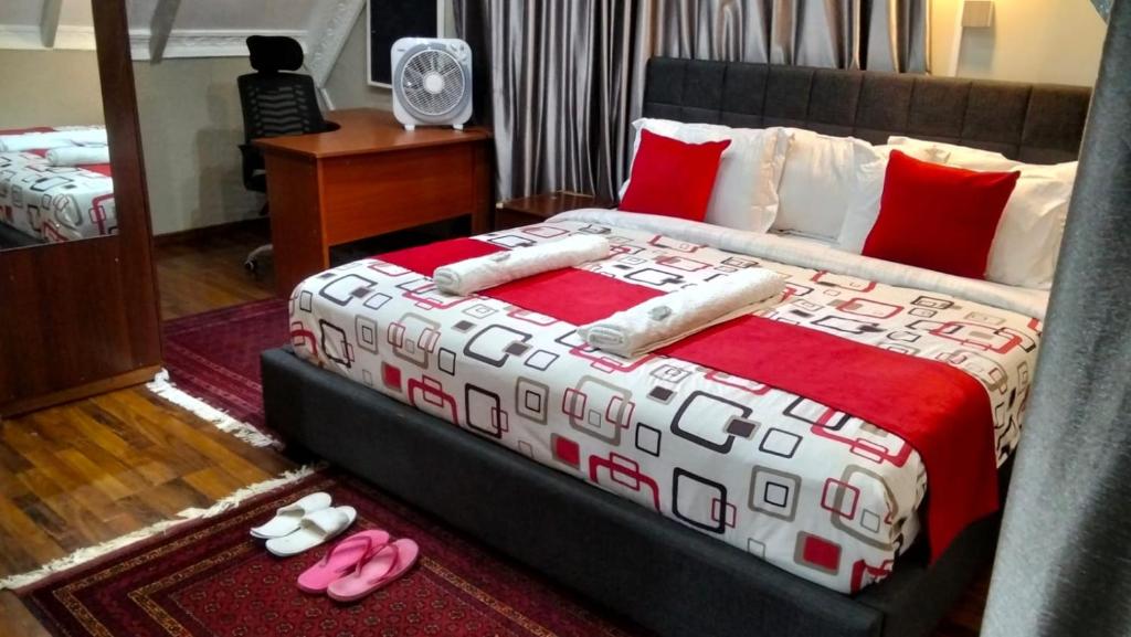 a bedroom with a bed with pink slippers on the floor at Kukis Place, 5 bedrooms, whole compound in Embu