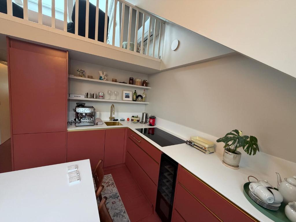 eine Küche mit roten Schränken und eine Treppe in der Unterkunft Kaffee Changé in Gent