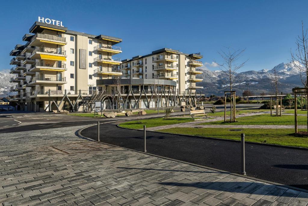 a hotel and a park with benches and a building at Alp Art Hotel Monthey in Collombey