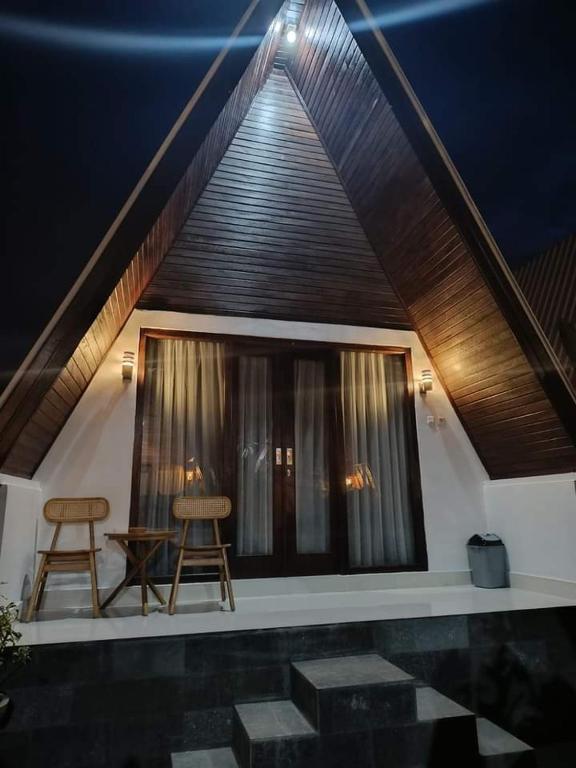 two chairs and a table in front of a window at Mahadanu Kintamani Private Villa in Kintamani