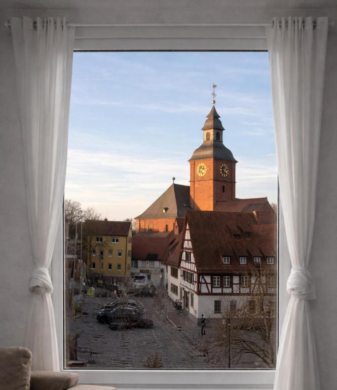 a view of a building with a clock tower from a window at Walldürn Zentrum 2 in Walldürn