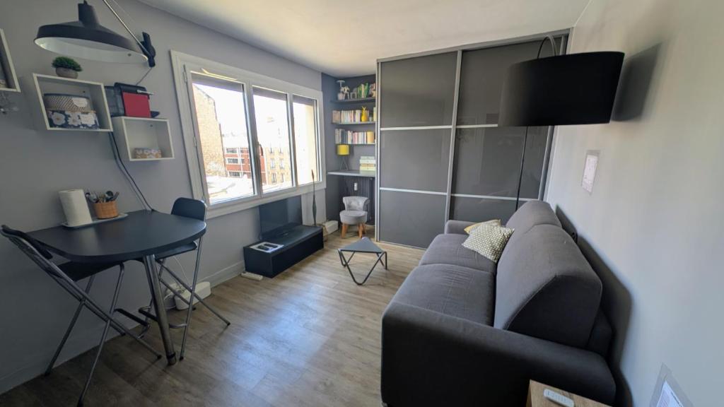 a living room with a couch and a table at Studio cosy à deux pas de Paris in Clichy