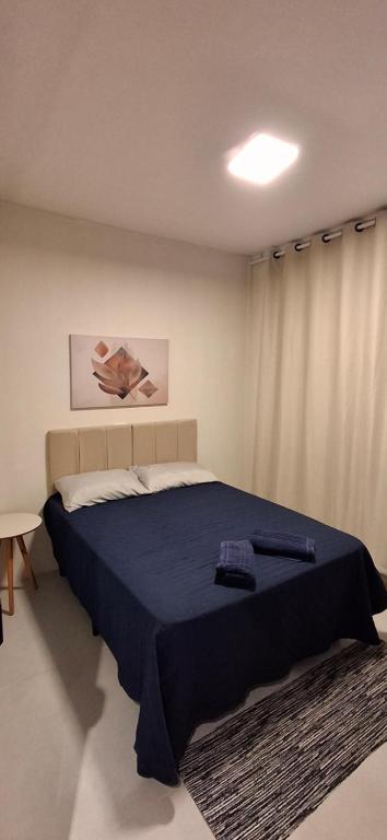 a bedroom with a large bed with a blue blanket at Vieira's Residencial in Embu