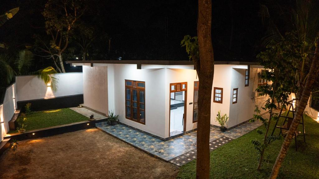 a small white house with a courtyard at night at Golden Breeze Mirissa in Kamburugamuwa