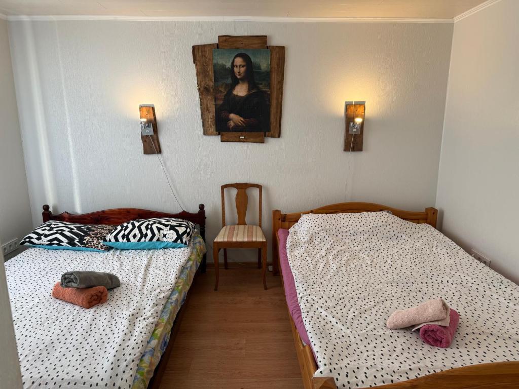 two beds in a room with a picture on the wall at Piiri 12, white Apartment - 2 big beds - Very Cute Apartment in Tartu