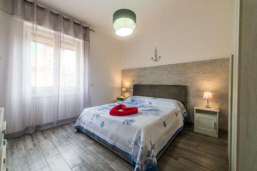 a bedroom with a bed with a red item on it at Di Giuseppe Laura in Ladispoli