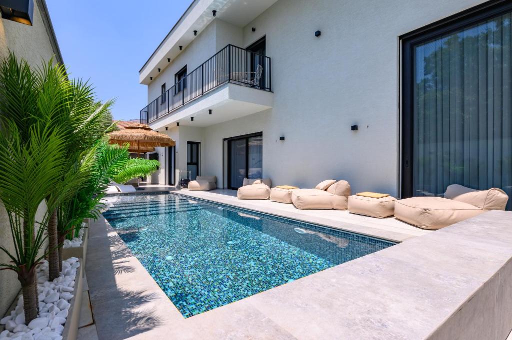 a villa with a swimming pool and a house at אחוזת דוד - וילה יוקרתית עם בריכה פרטית מחוממת ומקורה in Hatzor haglilit
