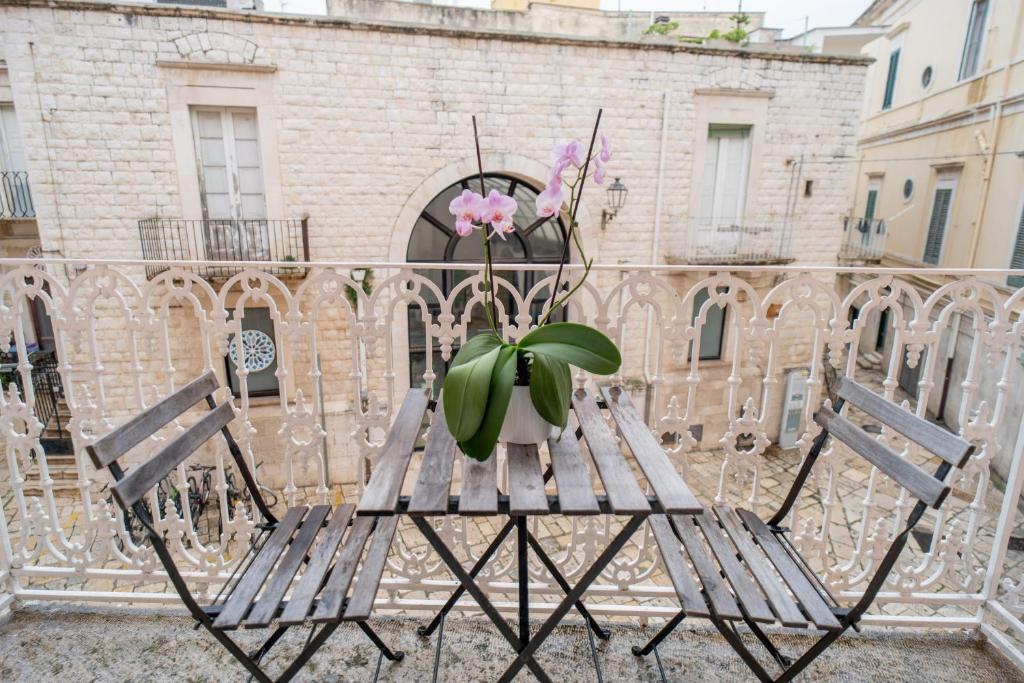 a potted plant sitting on a bench in front of a building at Il Da Vinci Apartment in Giovinazzo
