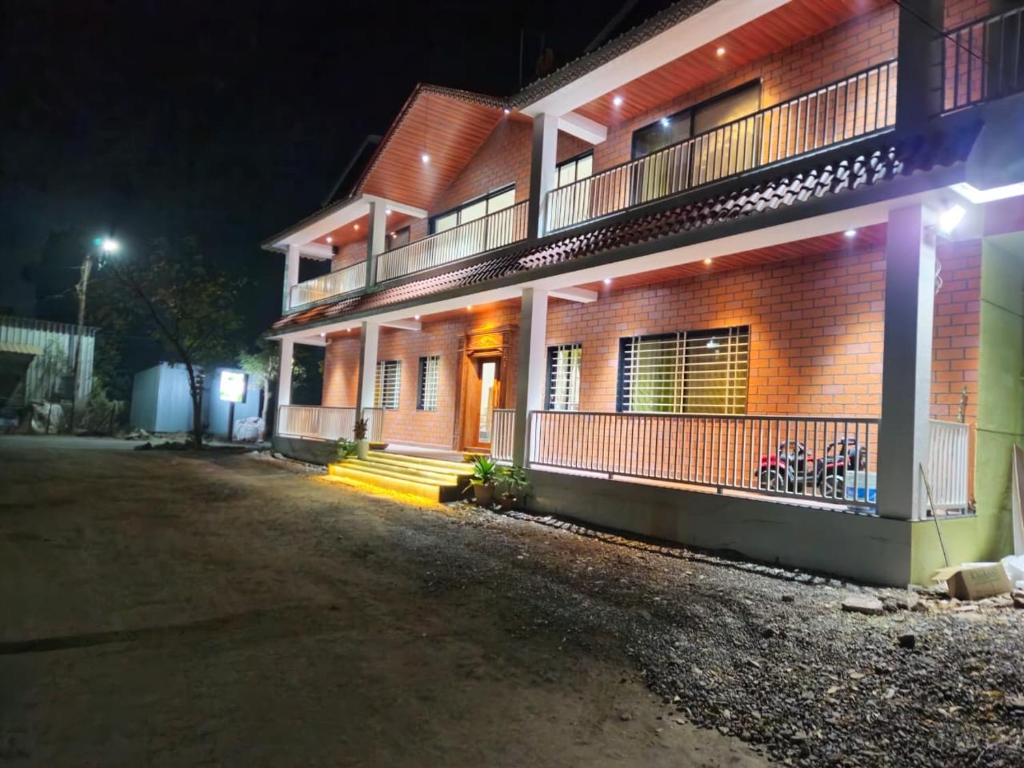 a brick building with a balcony at night at Aanandi Resort in Shirdi