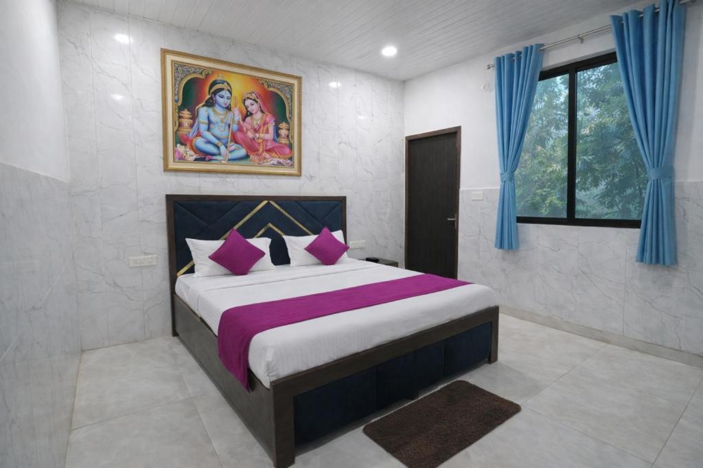 a bedroom with a king sized bed with purple pillows at Hotel Bhavishyaa Vrindavan in Vrindāvan
