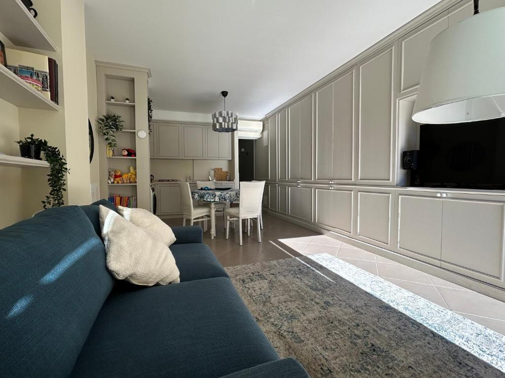 a living room with a blue couch and a dining room at Blue Roof in Fidenza