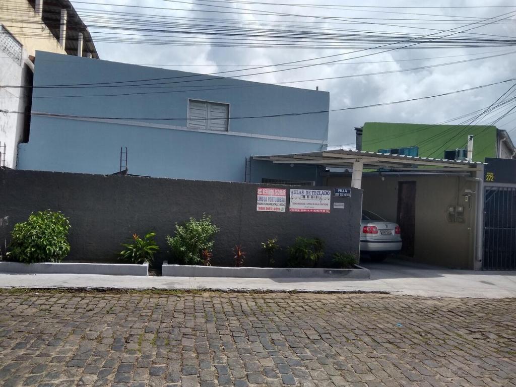 a blue building with a car parked in front of it at Casa Wense - prox a praia in Ilhéus