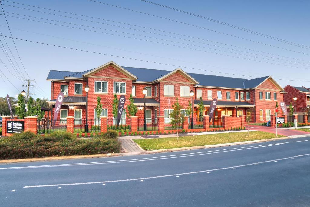 a large red brick house with an orange fence at Best Western Plus Bolton on the Park in Wagga Wagga