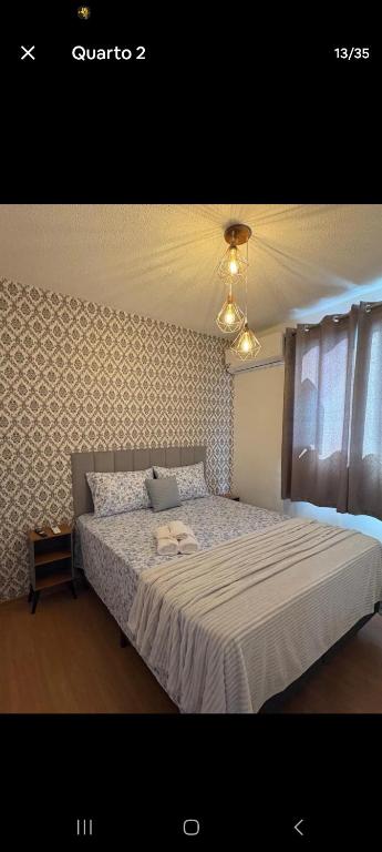 a bedroom with a bed with a laptop on it at Apartamento Próximo Arena pantanal in Cuiabá