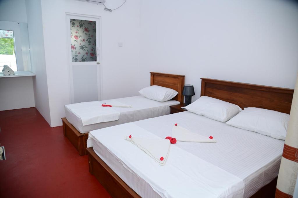 two beds in a room with baseball bats on them at Amila Resort - Habarana in Habarana