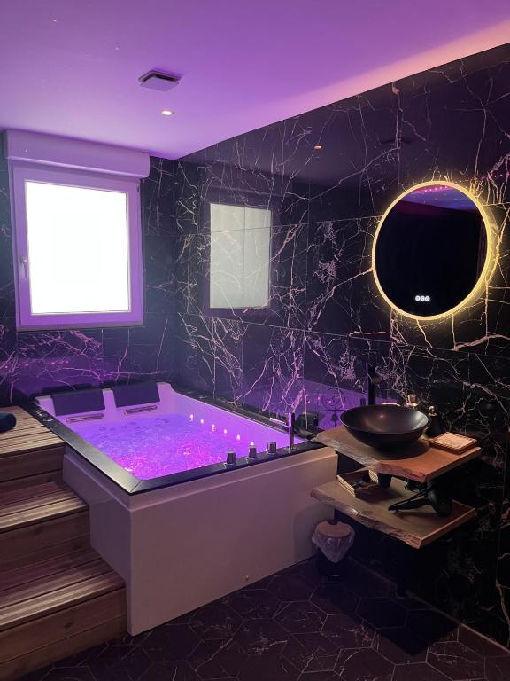 a purple bathroom with a tub and a sink at Suite Spa Sauna - Charleville - UNE PARENTHESE ARDENNAISE in Charleville-Mézières