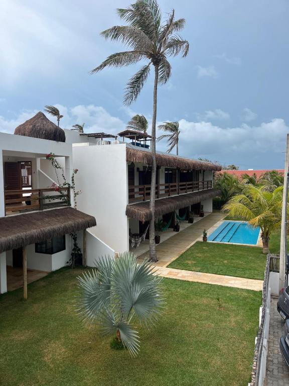 an external view of a resort with a swimming pool at Pousada Maresia in Guajiru