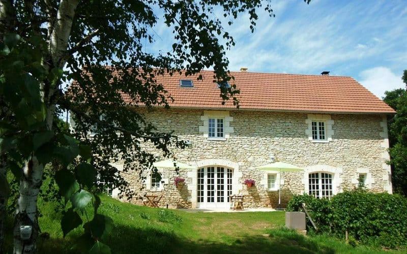 a large stone house with a red roof at la grange du coudert in Saint-Cybranet