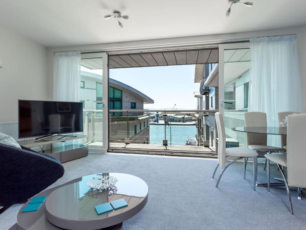 a living room with a view of the ocean at Jibe Ho - Beautiful Spacious Apartment with Harbour Views in Poole