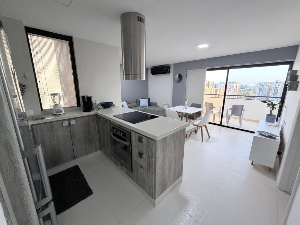a kitchen with a sink and a table with chairs at Playa el Ángel Apartment in Pampatar