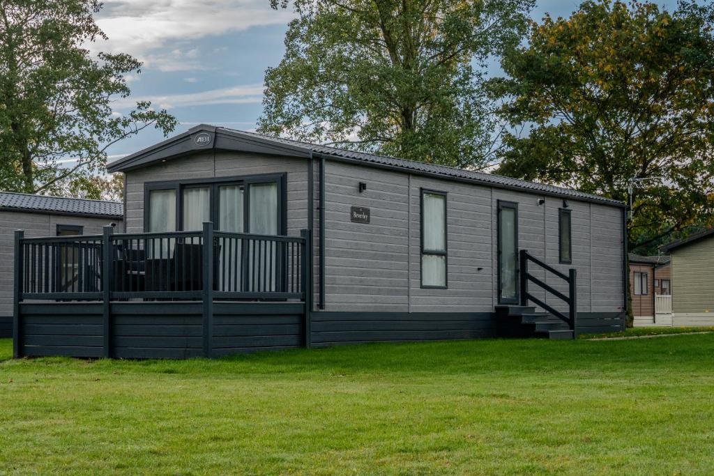 a small house with a fence in a yard at Oakmont Lodge in Allerthorpe