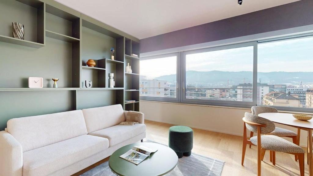 a living room with a couch and a table at Alto-Tower Residence - Self Check In in Zurich