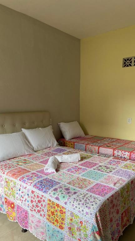 two beds sitting next to each other in a room at Flat casa de madeira in São José da Coroa Grande