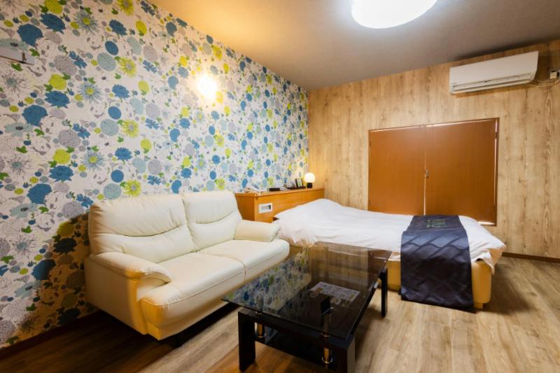 ein Wohnzimmer mit Sofa und Bett in der Unterkunft HOTEL Fiore Nakagawa -Adult Only- LOVE HOTEL in Nagoya
