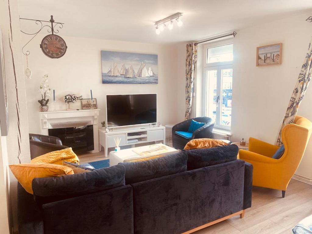 a living room with a couch and a tv at Au Cœur d Etaples in Étaples