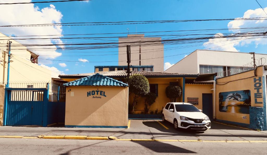 a white car parked in front of a building at Hotel Bellamy in São Paulo