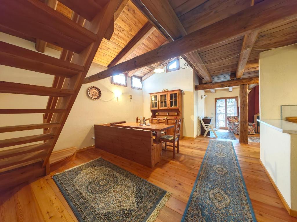 a large living room with wooden floors and wooden beams at Hostdomus - Flower Loft in Cesana Torinese